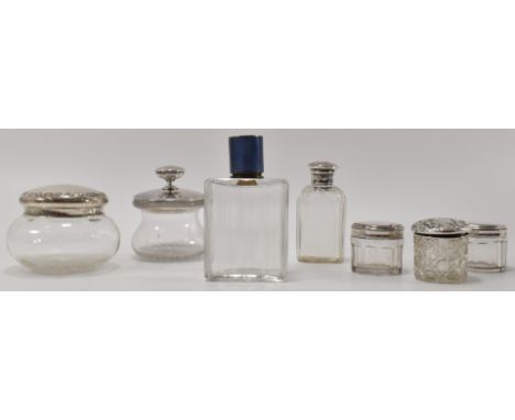 A collection of hallmarked silver lidded vanity items to include two large cotton wool jars, three smaller pots with one havi