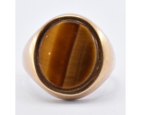 A hallmarked 9ct gold signet ring set with an oval tigers eye panel to the head. Hallmarked Birmingham 1979. Weight 5.6g. Siz