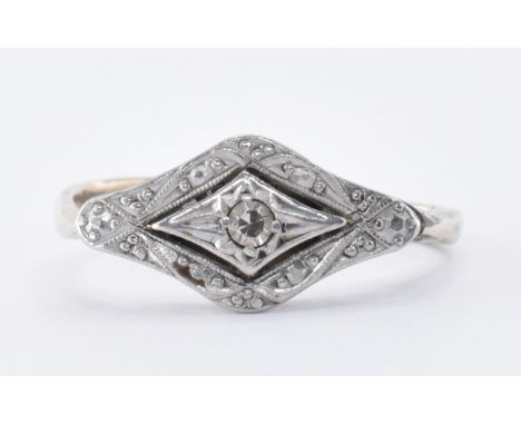 A 1930's Art Deco platinum and 9ct gold ring having a quatrefoil shaped head set with a central round cut diamond. Marked pla