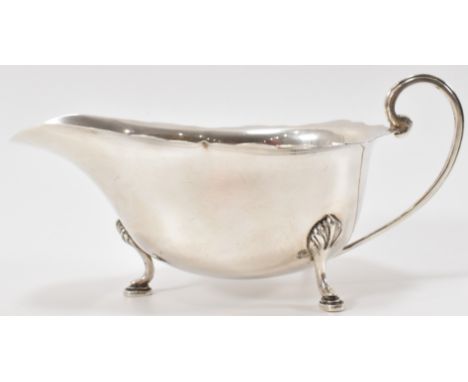 A 1930's&nbsp;Synyer &amp; Beddoes silver hallmarked gravy boat / creamer jug having shaped rims raised on foliate supports. 