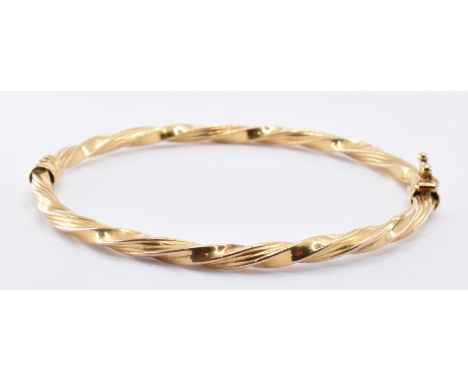 A 9ct gold twist design bangle bracelet having a hinged opening with catch to the clasp. Unmarked but tests indicate 9ct gold