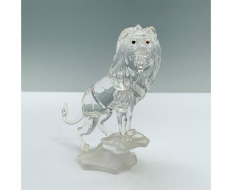 A majestic lion with a flowing mane stands at the edge of a rock, unleashing a powerful roar. Swarovski backstamp. This item 