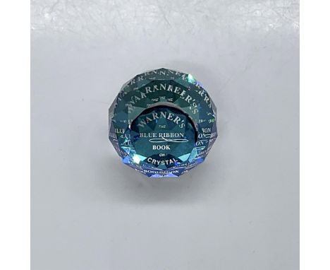 This clear faceted crystal paperweight with a blue internal base and felt bottom was created to honor Warner's Swarovski book