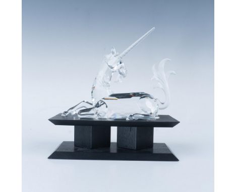 A clear faceted figure of a horse-like mythical creature lying down with black eyes and frosted hair, mane and horn. 1996 Swa