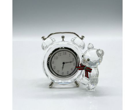 Clear crystal clock with rhodium alarm features and feet. Bear has clear crystal body, amber eyes and plaid bow. Swarovski ba