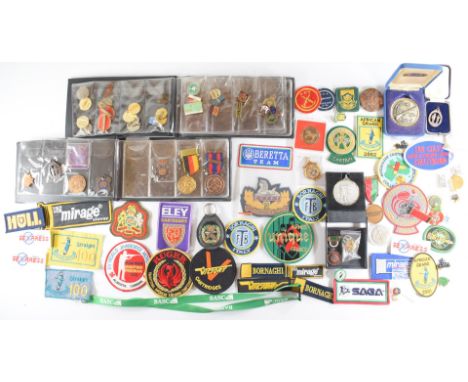 A collection of gun and shooting related badges, patches and medals including Gloucestershire Regiment blazer badge, Territor