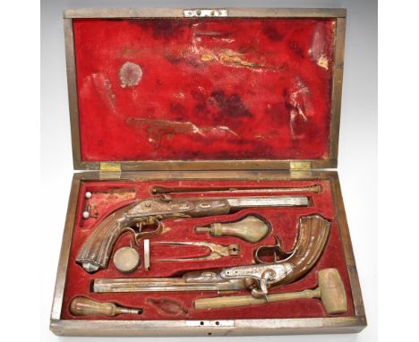 A cased pair of target or duelling pistols, each with engraved lock, hammer spurred trigger guard and top strap, reeded grip 