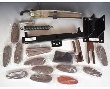 A portable shotgun clay pigeon trap together with 12 shotgun recoil pads, comb raisers and leather hand guards, all unused.&n