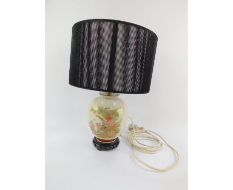 A Japanese pottery table lamp decorated with pheasants and peonies, black shade, 44cm high.