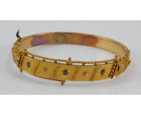 A Victorian 9ct gold sapphire and diamond set bangle, on a snap clasp with safety chain as fitted, 12.8g.