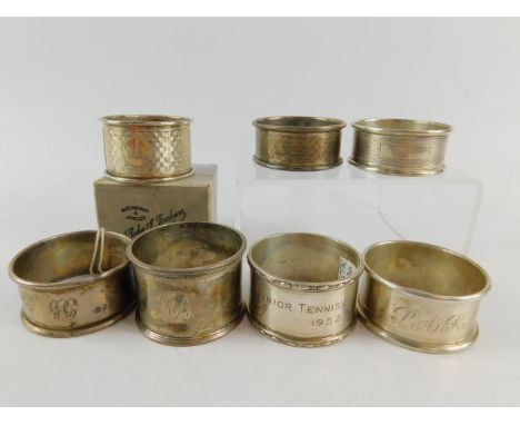 Three silver napkin rings, with engine turned decoration, one cased, three other napkin rings, monogram engraved, and a napki