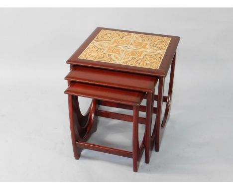 A nest of 1970's G Plan occasional tables, with a scumbled finish, the largest with tile inset top, 50cm x 50cm x 50cm.