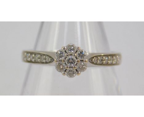 An 18ct white gold and diamond set flower head ring, with diamond set shoulders, approx 0.3cts size K, 2.9g.