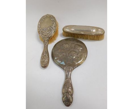 An Edward VII silver backed hand mirror, embossed with cherub's heads, Birmingham 1905, silver backed hair brush embossed wit