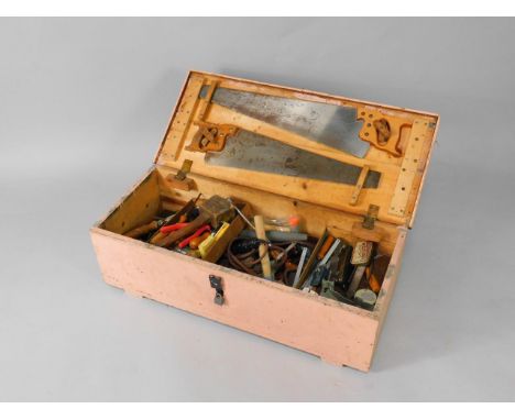 A pink painted pine tool chest, containing chisels, hammers, saws, etc.