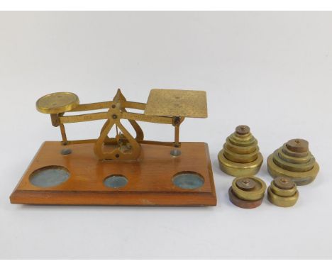 A set of early 20thC brass postal scales, on a wooden base,  together with a set of weights.