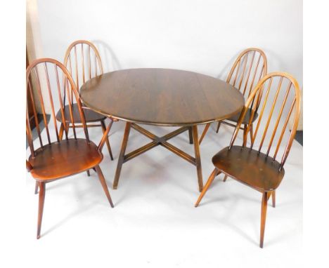 An Ercol circular oak dropleaf dining table, raised on tapering channelled legs, united by an X framed stretcher, together wi