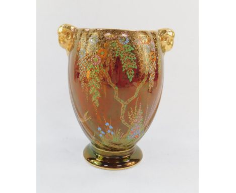 A Crown Devon rouge pottery vase, early 20thC, of twin ram's head handled ovoid footed form, enamel and gilt decorated with a