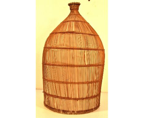Fish trap woven in fine rattan. A trap like this would be laid in a river, the small end covered with a plastic bag. It has b
