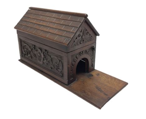 Late Victorian oak box in the form of a dog kennel with hinged roof, carved panels to the sides and arched opening to one end