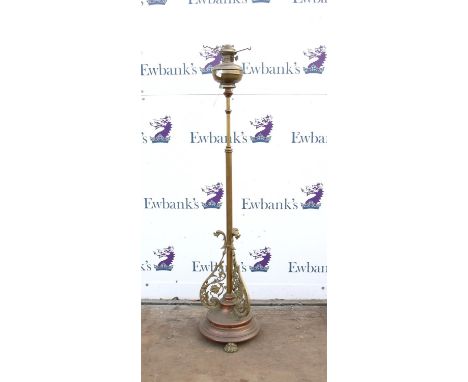 Brass standard oil lamp, with three scroll form brackets on a circular base and paw feet, 150 cm high (no shade)
