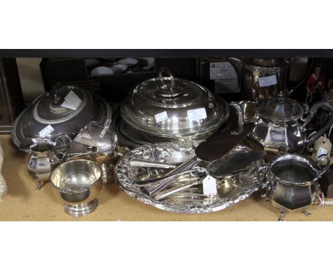 Two three piece silver plated tea services, two oval tureens and covers, a helmet shaped sugar scuttle, chased dish and flatw