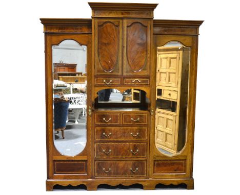 Edwardian inlaid mahogany triple wardrobe, breakfront with moulded cornice, central section with cupboard above dtawers, flan