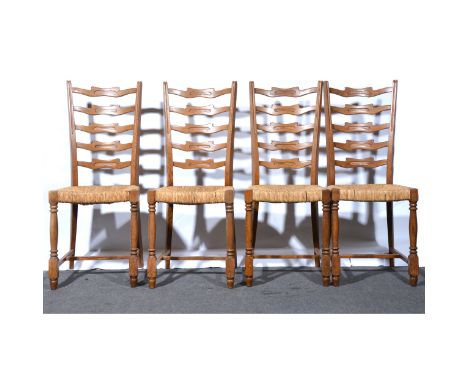 Set of four Arts &amp; Crafts inspired oak wavy ladder-back dining chairs, with rush seats, width 41cm.