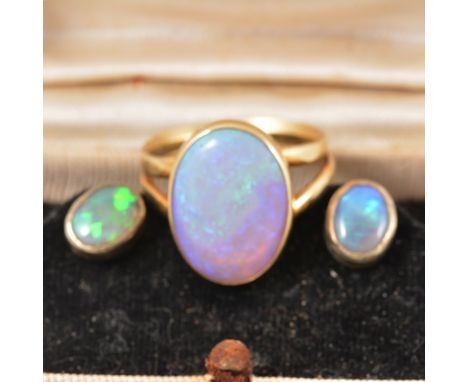 An oval cabochon cut opal 16mm x 12mm collet set in a yellow metal mount closed back on a double shank ring size R, gross wei