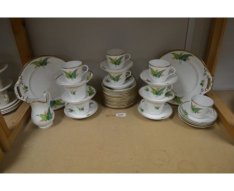 A Continental porcelain tea service for nine, painted with fern sprigs, gilt dental bands, comprising bread plates (2), milk 