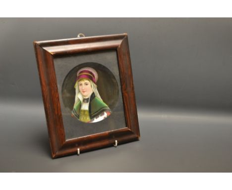 A KPM style porcelain dish, painted with a portrait of a juvenile in traditional dress, 13.5cm diam, framed 