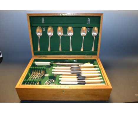 An Edwardian oak cased silver plated canteen inc. bone handle knives, serving spoons etc. 