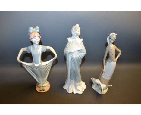 A Nao figure of a girl dressed as a clown, D-170; a Nao figure of a woman in a shawl holding a fan; a Lladro figure of a youn