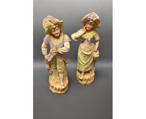 A pair of Continental painted bisque porcelain figures modelled as a grape pickers, Numbered 3365, 33cm high 
