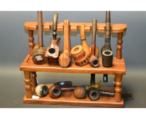 A Bavarian two tier pipe rack mounted with twelve assorted pipes including carved bowl etc