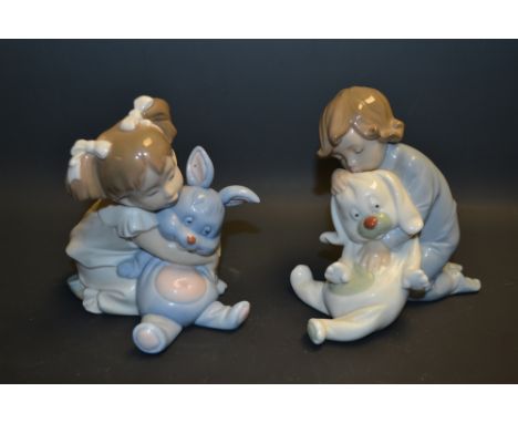 A pair of Nao figures, a boy and girl playing with their soft bunnies, printed and incised marks 
