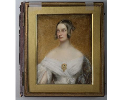 Early 19th century English Schooloil on ivoryPortrait miniature of a lady, half length wearing a white gown and emerald and g