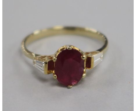 A 14ct and ruby ring with tapered cut diamond set shoulders, size L.