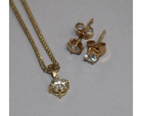A gold and solitaire diamond set pendant on an 18ct gold chain and a pair of 18ct gold and solitaire diamond ear studs.