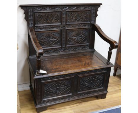 A carved oak monk's bench W.99cm