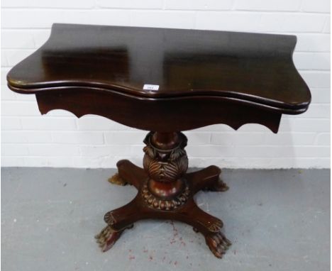 Mahogany fold over card table with serpentine top and leaf carved baluster column, on quadruped base raised on hairy pay feet