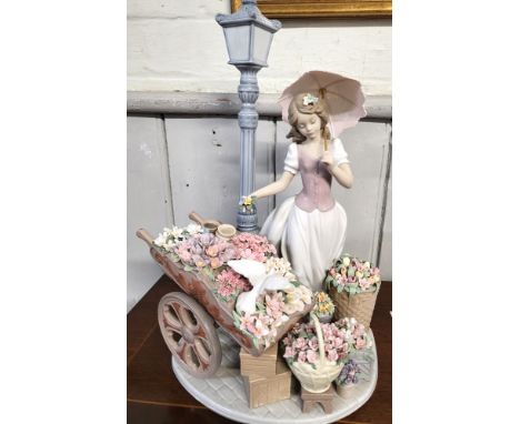 Lladro flower seller figure of young lady with parasol, barrow and baskets of flowers and lamp post, 38cm.In very good condit
