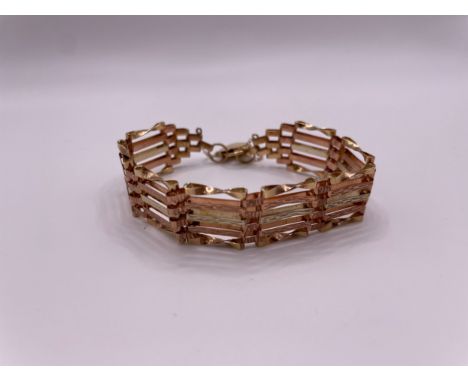 A 9ct yellow and rose gold gate-link bracelet, with twisted and textured links, heart-shaped locket clasp.&nbsp;10.1 grams