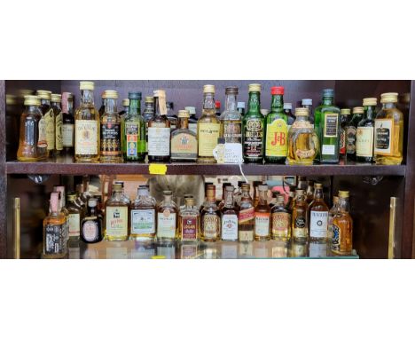 A large selection of miniature whiskeys including Bell's, Mackinlay, Seagram's 100 Pipers, Passport Scotch, White Horse, Pig'