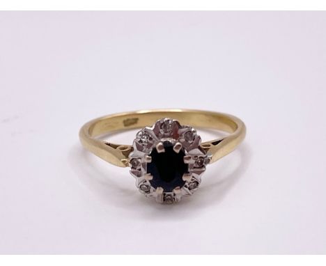 An 18ct yellow gold, diamond, and sapphire cluster ring, the shank marked 18ct, size P, 3.6 grams. 