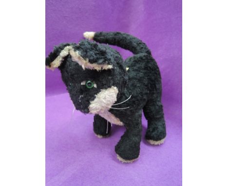 A vintage straw filled black and white cat having plastic eyes