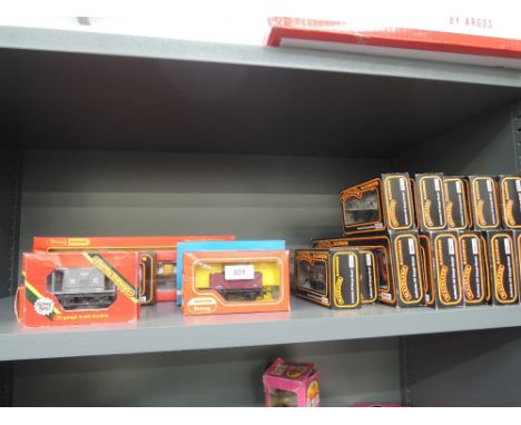 A shelf of Mainline, Hornby and similar 00 gauge rolling stock and carriages, all boxed