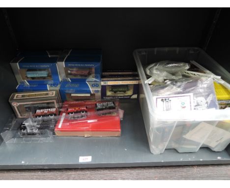 A shelf of 00 gauge rolling stock and accessories, most items boxed