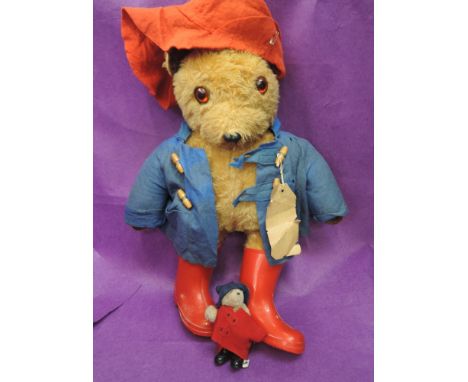 A vintage Paddington Bear, having Darkest Peru label, wearing blue jacket, red hat and wellingtons along with a similar minia