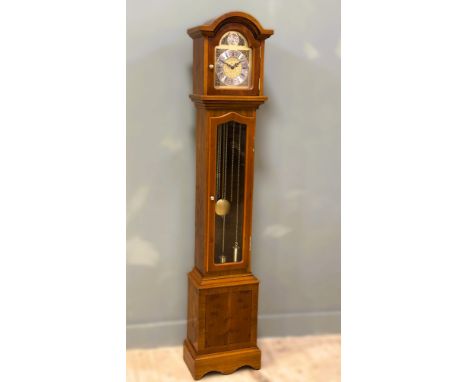 A yew wood longcase modern clock with brass dial and westminster chiming movement and glazed panel door on bracket feet: h. x